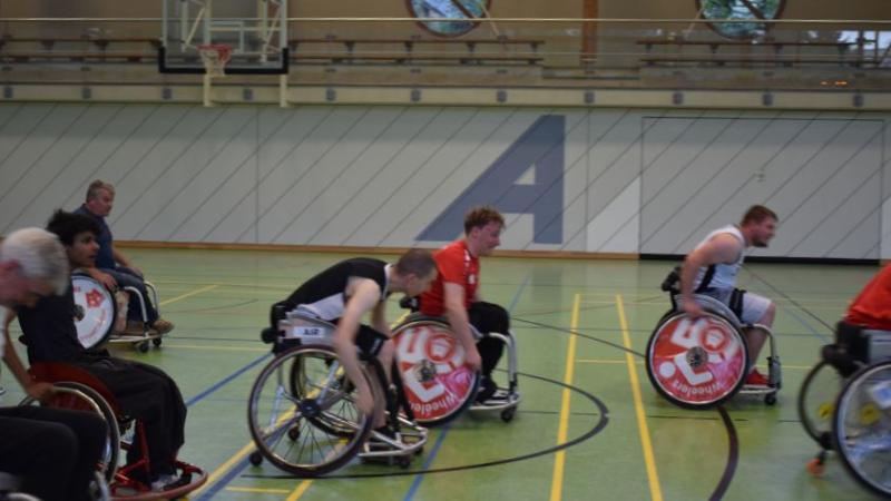 Die Spielenden rasen in einem bewegten Bild auf den Basketballkorb zu.