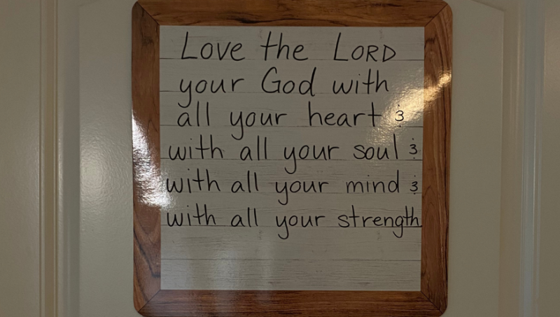 Ein Bild von einem Bibel Vers, der im Haus hängt.