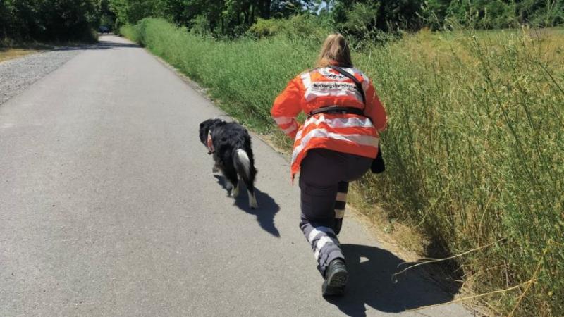 Frau rennt Hund hinterher