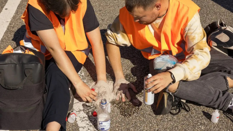 Der Klimaaktivist Moritz Riedacher klebt sich mit einer Mitstreiterin auf die Straße. 