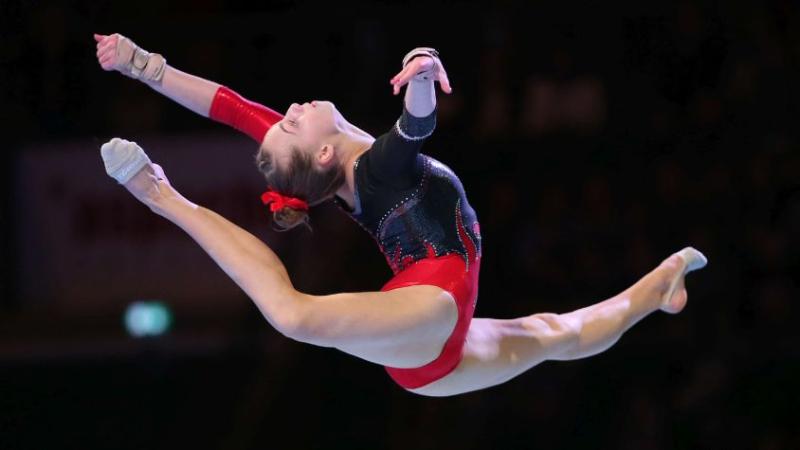 Carina Kröll ist im Überspagat mit angewinkeltem Fuß zu sehen.
