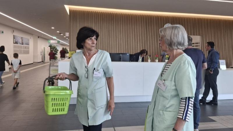 Zwei Grüne Damen. Eine mit grünem Korb in der Hand.