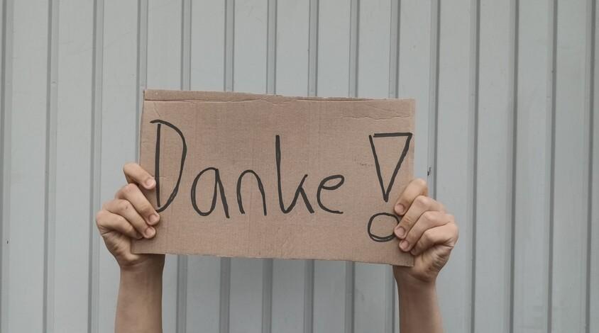 hochgehaltenes Schild mit dem Wort Danke