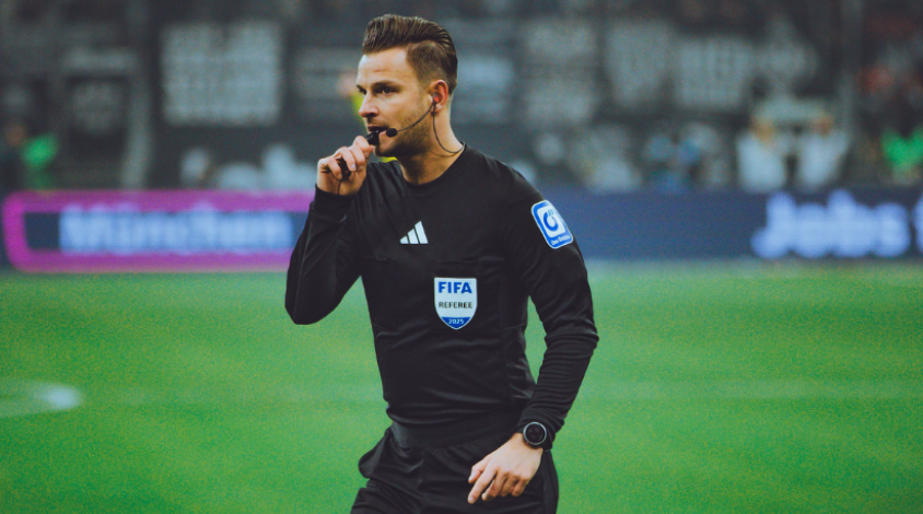 Schiedsrichter Daniel Schlager mit seiner Pfeife im Mund