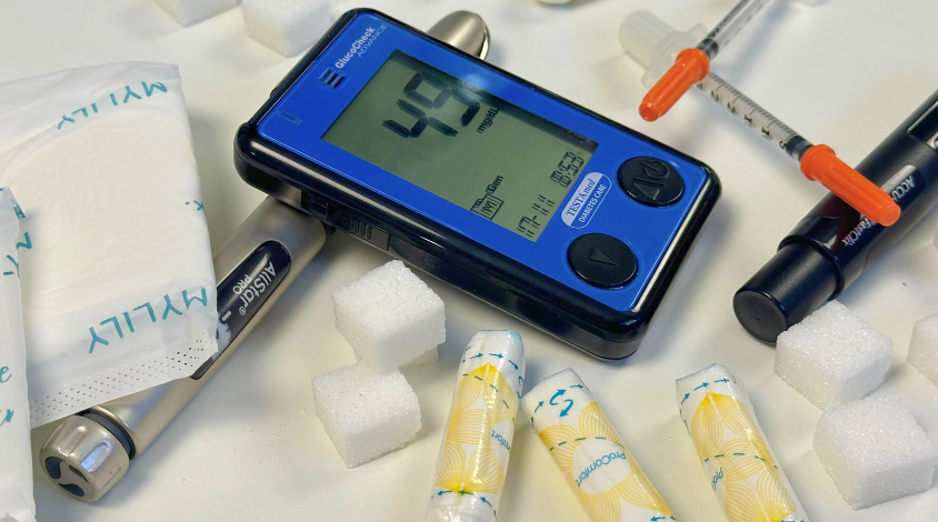Blutzuckermessgeräte, Hygieneartikel und Zucker liegen auf einem Tisch