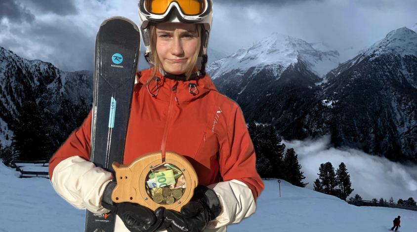 Skifahrerin mit Sparschwein in der Hand